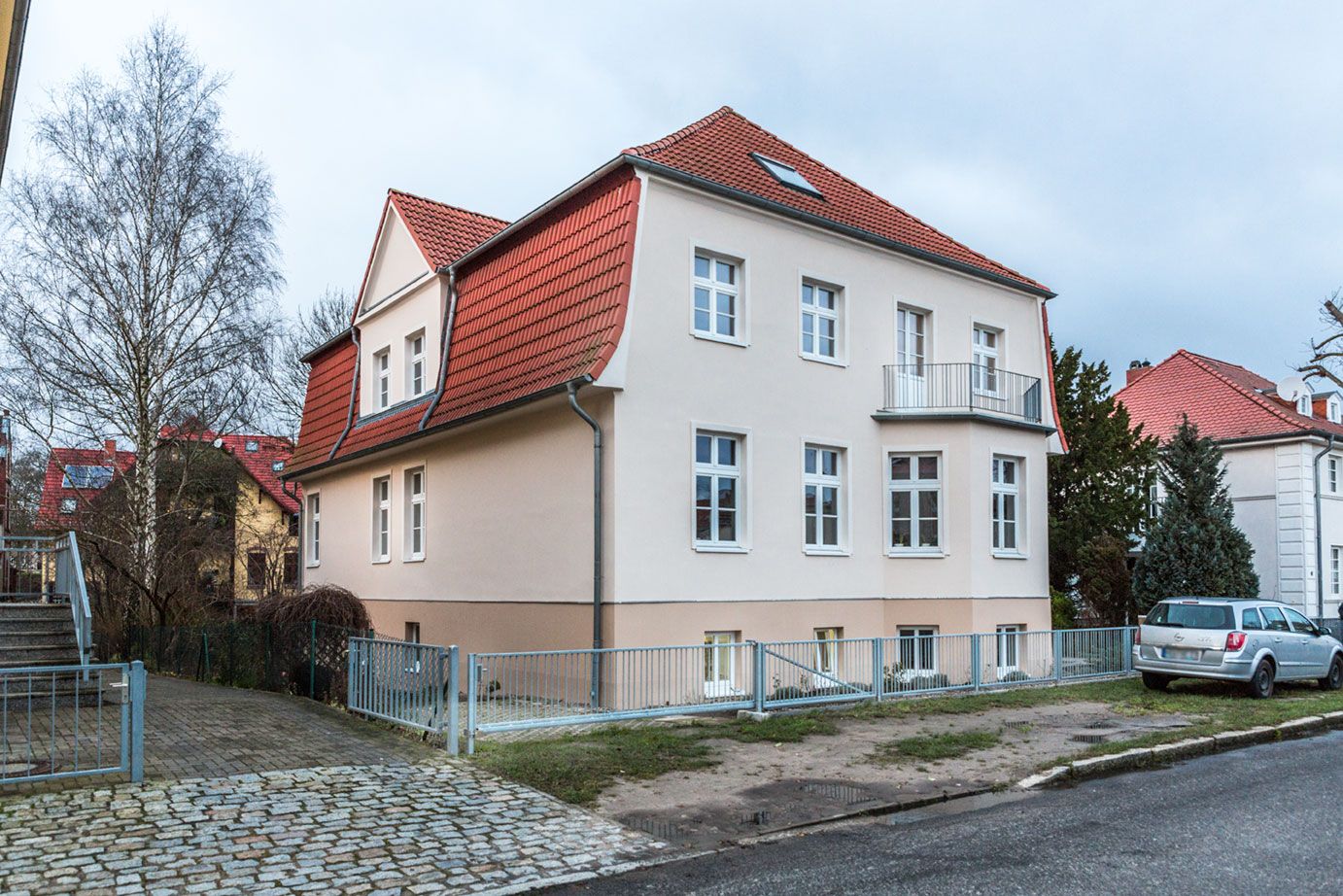 Gepflegte Hofseite eines Mehrfamilienhauses mit Stellplätzen